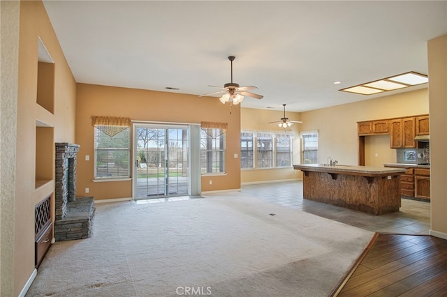 living room with a fireplace, plenty of natural light, and light colored carpet