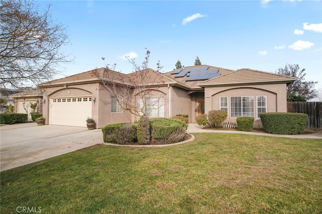 view of front of property featuring a garage, a front lawn, and solar panels