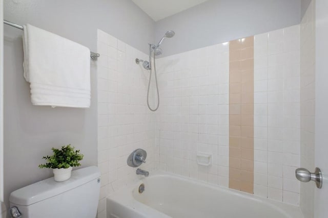 bathroom featuring tiled shower / bath combo and toilet