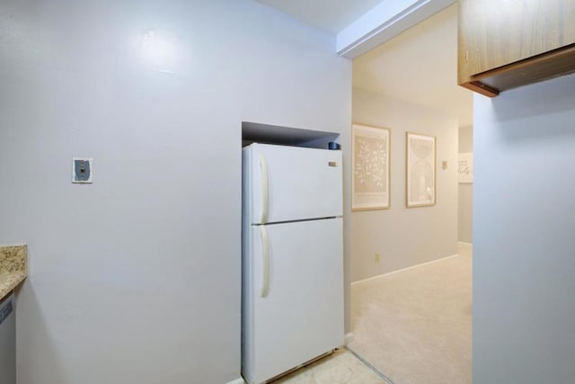 kitchen featuring light colored carpet, dishwasher, and white fridge