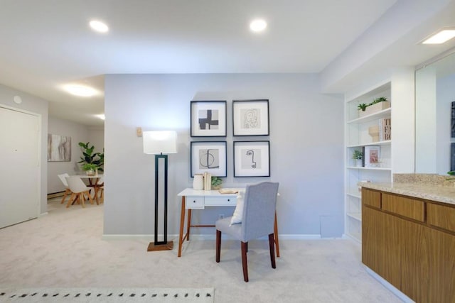 office area with a baseboard heating unit, light colored carpet, and built in shelves