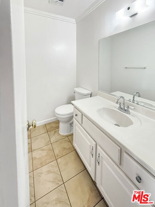 bathroom featuring crown molding, vanity, tile patterned floors, and toilet