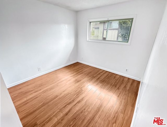 spare room with hardwood / wood-style flooring