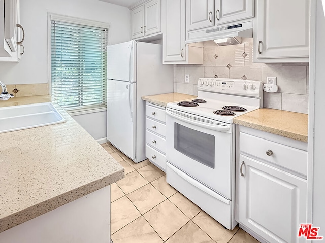 kitchen featuring light tile patterned flooring, white appliances, sink, and white cabinets