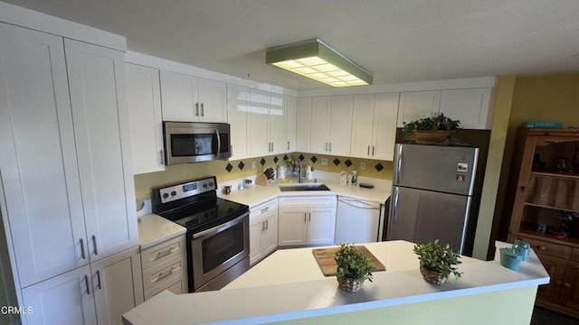 2713 Antonio Dr Unit 104, Camarillo, CA 93010 - kitchen featuring appliances with stainless steel finishes, white cabinets, light countertops, and a sink