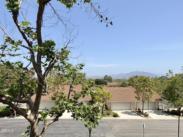 2713 Antonio Dr Unit 104, Camarillo, CA 93010 - obstructed view of property with driveway, a tile roof, an attached garage, a mountain view, and stucco siding