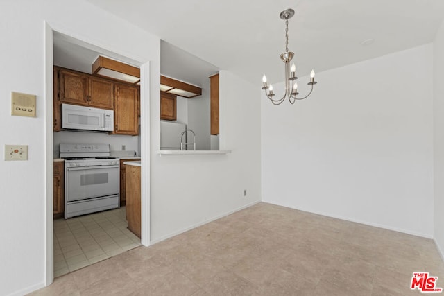 kitchen with an inviting chandelier, white appliances, and decorative light fixtures