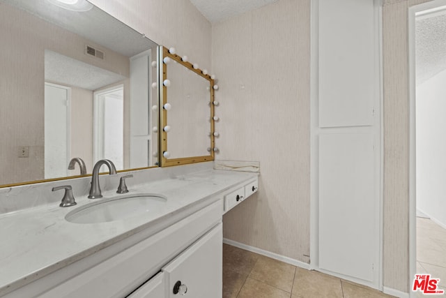 bathroom with tile patterned floors, vanity, and a textured ceiling