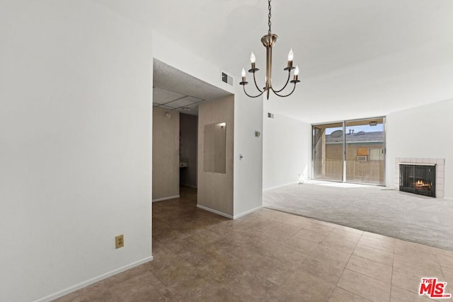 unfurnished dining area featuring expansive windows, a tile fireplace, carpet floors, and an inviting chandelier