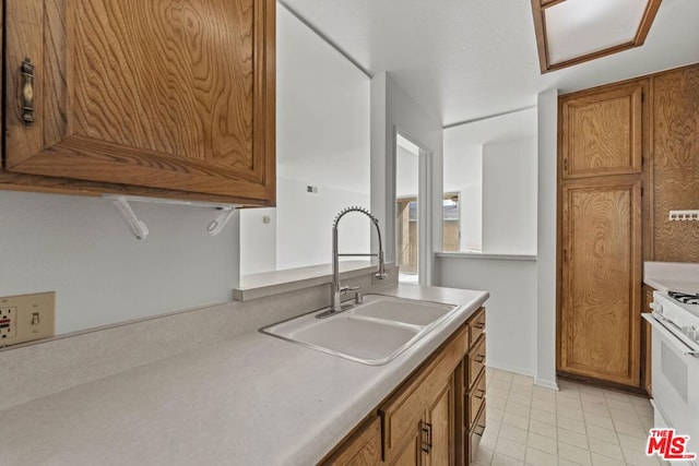 kitchen with sink, gas range gas stove, and light tile patterned floors