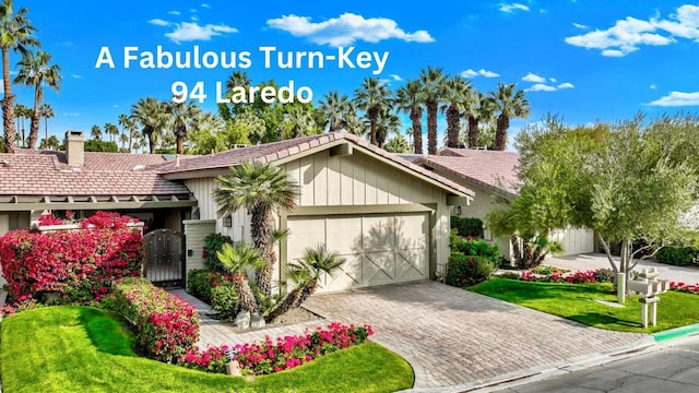 view of front of home with a garage and a front lawn