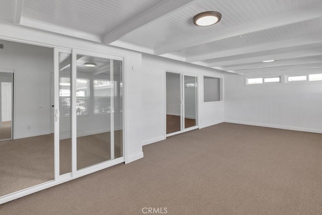 spare room featuring beam ceiling and carpet floors