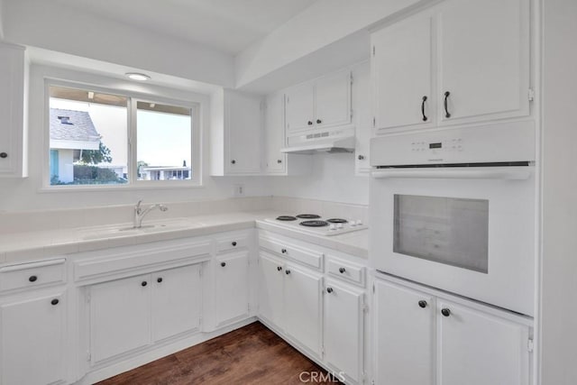 kitchen with sink, white appliances, tile counters, white cabinets, and dark hardwood / wood-style flooring