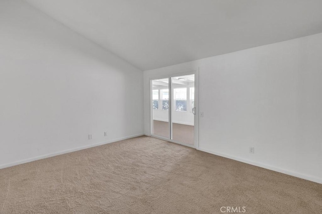 carpeted empty room with vaulted ceiling