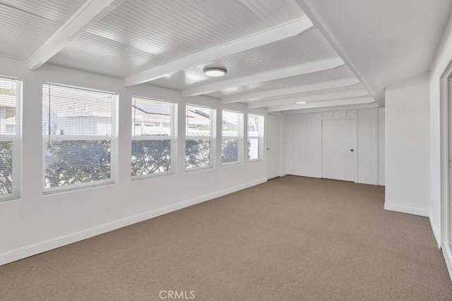 carpeted empty room with beam ceiling