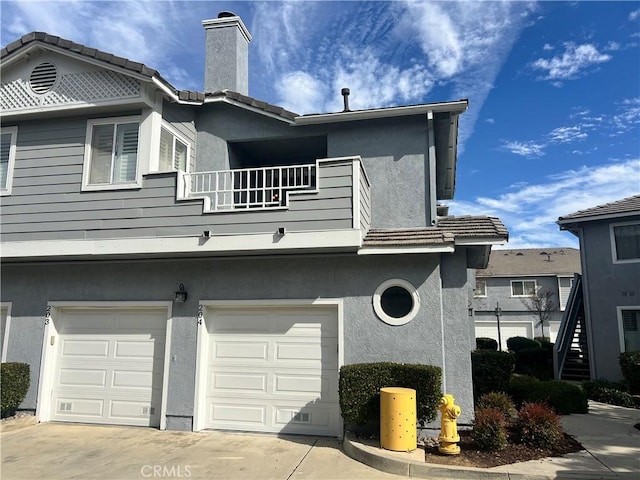 view of home's exterior featuring a garage and a balcony