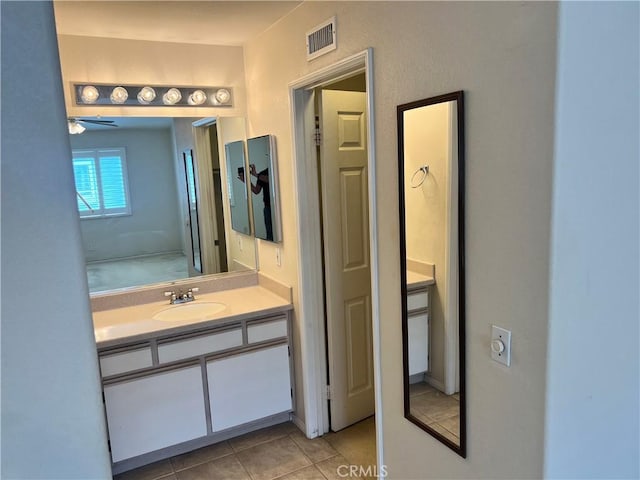 bathroom with tile patterned flooring, vanity, and ceiling fan