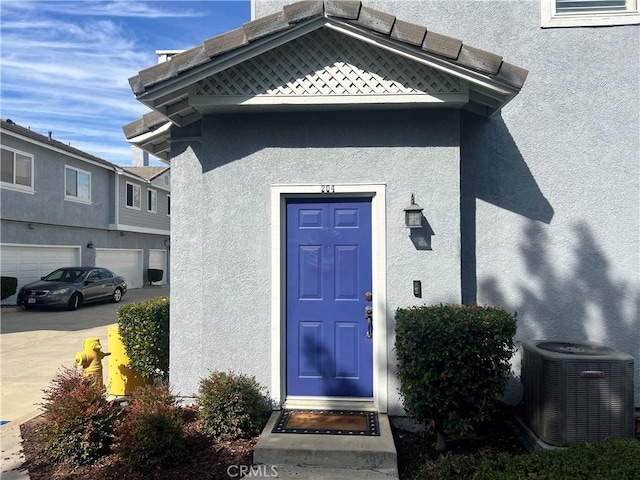 doorway to property with cooling unit and a garage