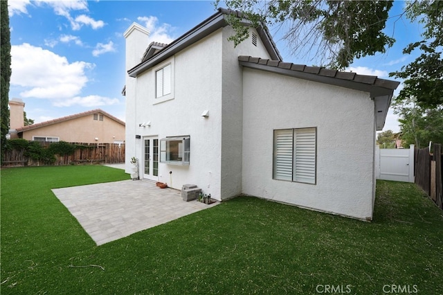 back of house with french doors, a yard, and a patio