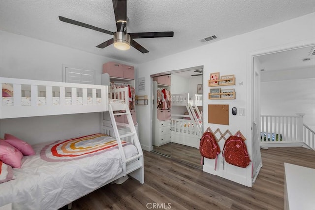 bedroom featuring ceiling fan, dark hardwood / wood-style flooring, a closet, and a textured ceiling