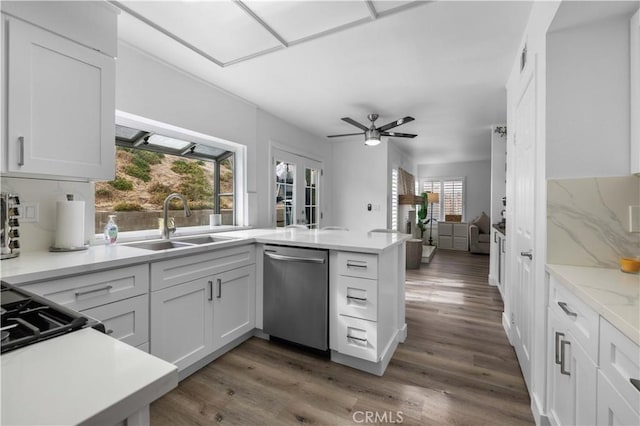 kitchen featuring white cabinetry, sink, stainless steel dishwasher, and kitchen peninsula