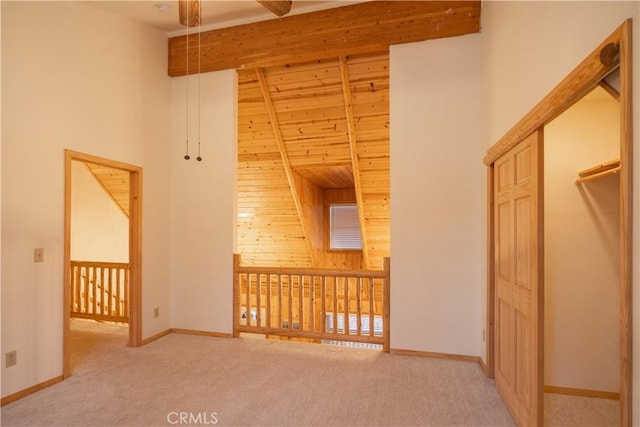 interior space featuring ceiling fan, carpet flooring, and a high ceiling