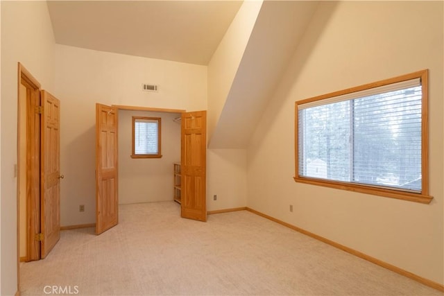 bonus room featuring lofted ceiling and light carpet