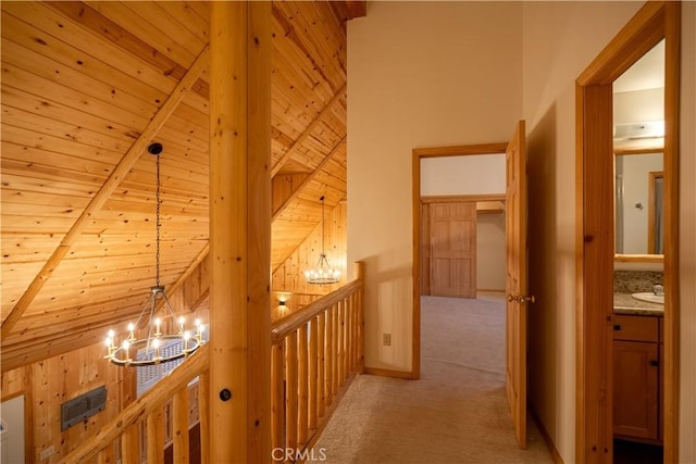 hall featuring wood ceiling, beamed ceiling, light carpet, and a notable chandelier