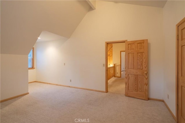 bonus room with light carpet and high vaulted ceiling