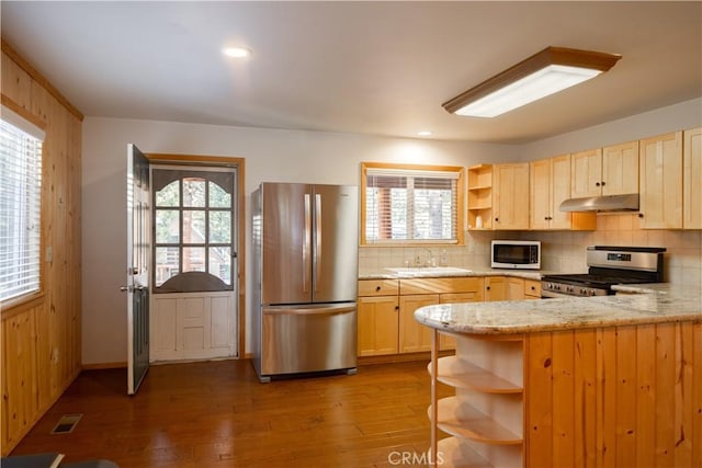 kitchen featuring appliances with stainless steel finishes, dark hardwood / wood-style floors, sink, kitchen peninsula, and light brown cabinets