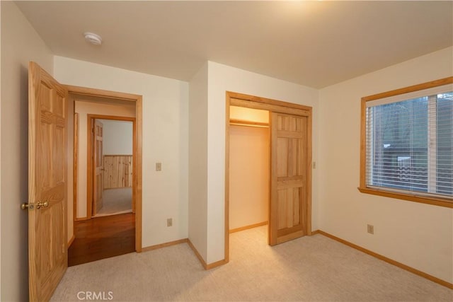 unfurnished bedroom with light carpet and a closet