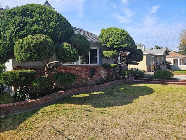 exterior space featuring a lawn and brick siding