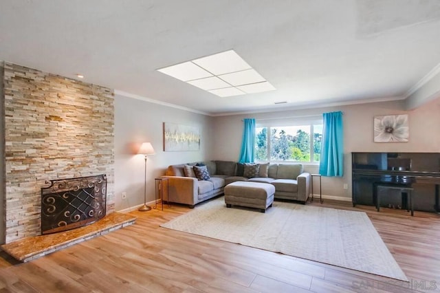 living room with ornamental molding, a fireplace, and light hardwood / wood-style flooring