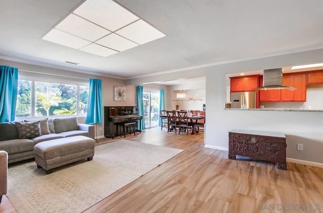 living room featuring crown molding and light wood-type flooring