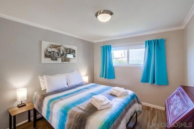 bedroom with dark wood-type flooring and ornamental molding