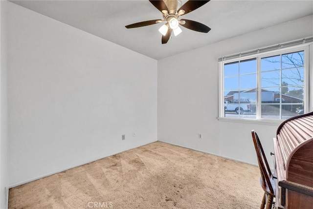 unfurnished office with ceiling fan and carpet floors