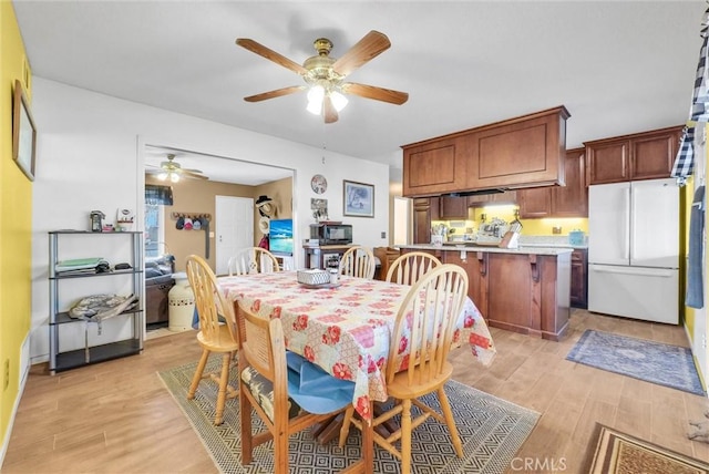 dining space with light hardwood / wood-style floors and ceiling fan