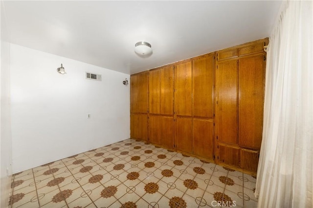 empty room featuring light floors and visible vents