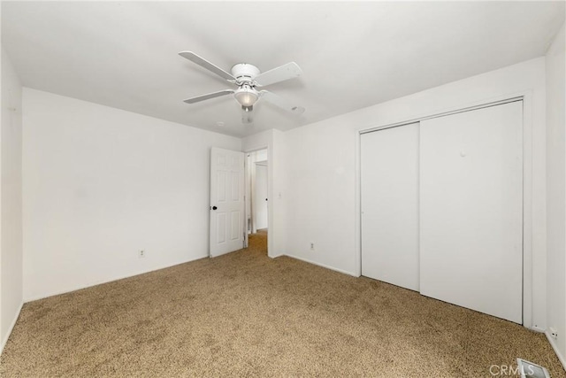 unfurnished bedroom featuring a ceiling fan, visible vents, carpet, and a closet