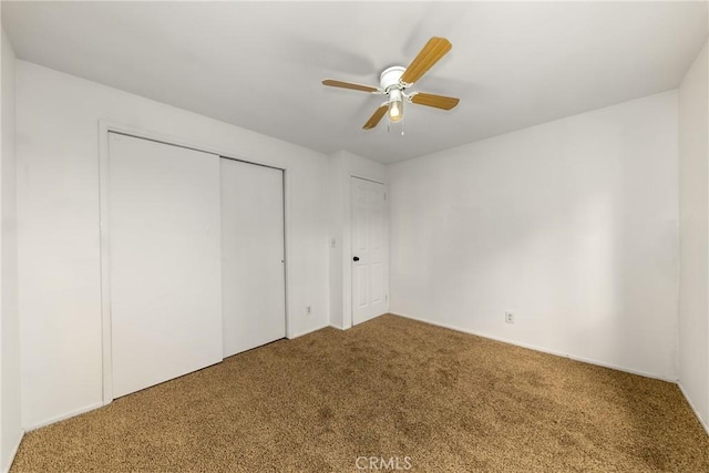 unfurnished bedroom with a closet, a ceiling fan, and carpet flooring