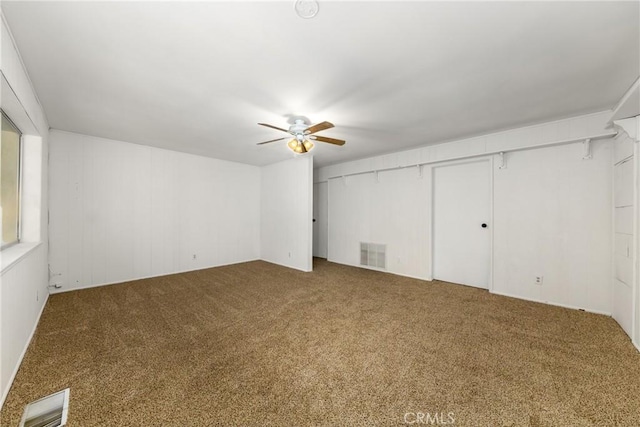 unfurnished bedroom featuring carpet flooring, a ceiling fan, and visible vents