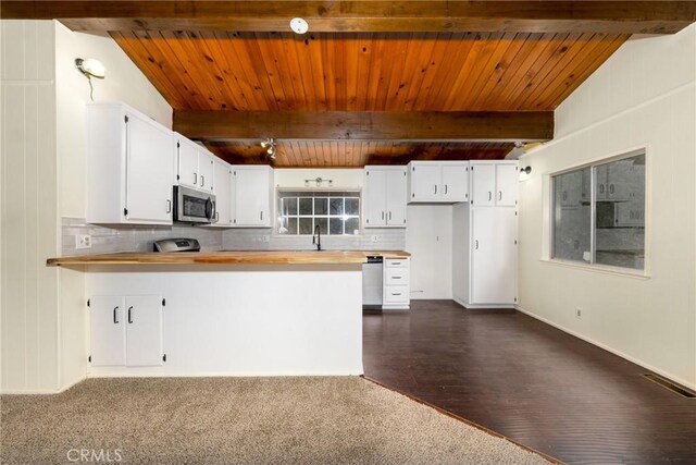 kitchen featuring a sink, stainless steel appliances, beam ceiling, and decorative backsplash