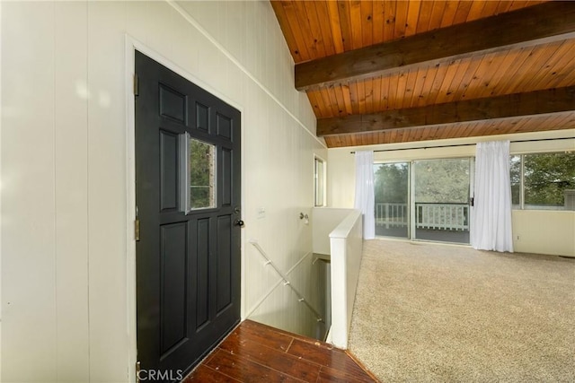 entryway with wood finished floors, carpet floors, beam ceiling, wood ceiling, and a decorative wall