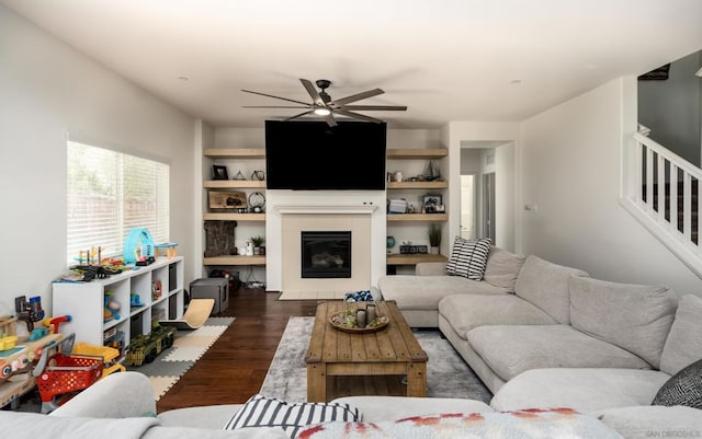 living room with dark hardwood / wood-style flooring and ceiling fan