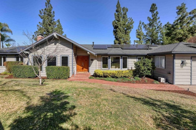 ranch-style house featuring a front yard and solar panels