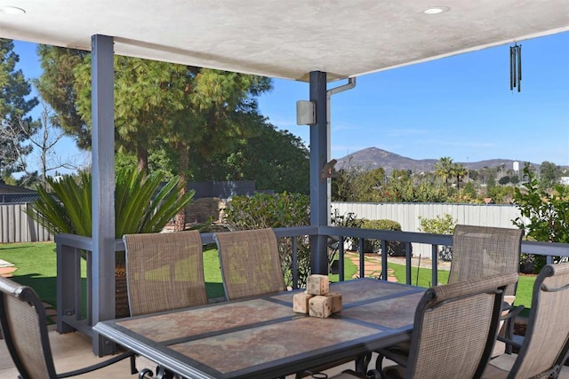 wooden deck with a mountain view and a lawn