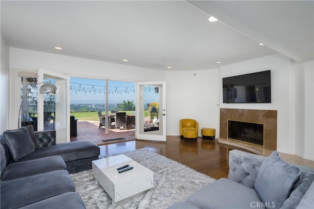 living room featuring a high end fireplace and dark hardwood / wood-style flooring