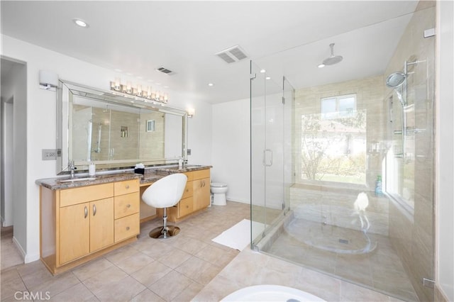 bathroom featuring vanity, tile patterned floors, a shower with door, and toilet