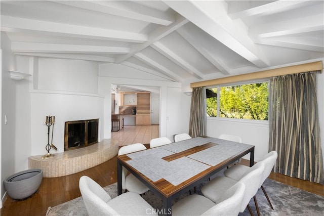 dining room featuring hardwood / wood-style floors and vaulted ceiling with beams