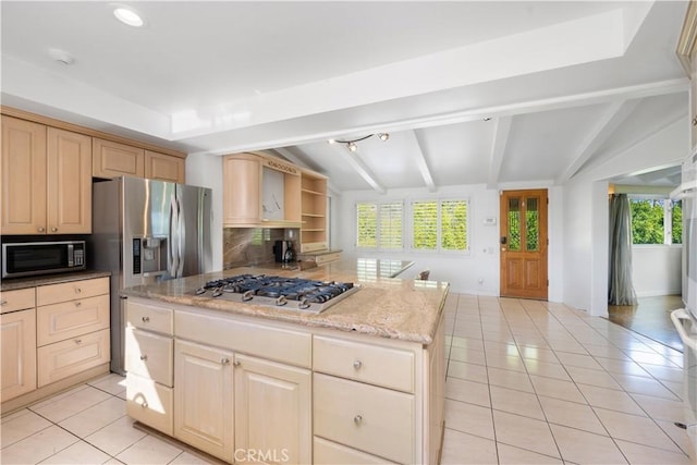 kitchen featuring appliances with stainless steel finishes, a center island, lofted ceiling with beams, light tile patterned flooring, and decorative backsplash